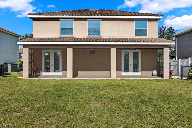 back of house with a lawn and french doors