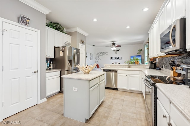 kitchen featuring ornamental molding, stainless steel appliances, a center island, and white cabinets