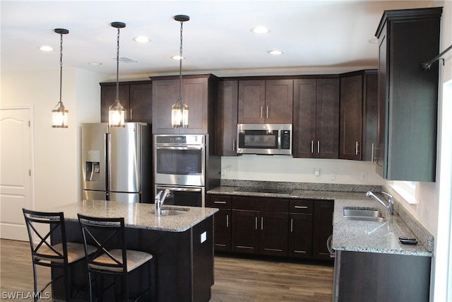 kitchen featuring sink, a center island, appliances with stainless steel finishes, and wood-type flooring