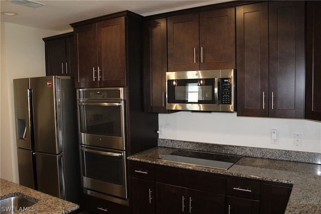 kitchen featuring dark brown cabinetry, stone countertops, and stainless steel appliances