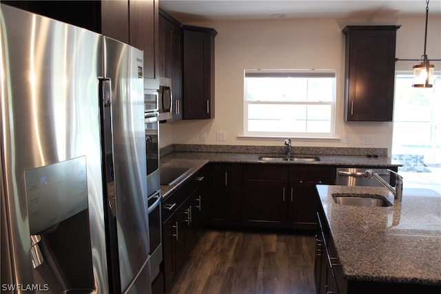 kitchen with stainless steel appliances, pendant lighting, sink, and dark wood-type flooring