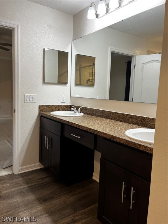 bathroom featuring hardwood / wood-style flooring and dual vanity