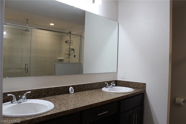 bathroom with dual vanity and walk in shower