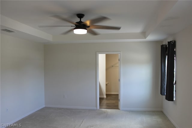 interior space with ceiling fan and a tray ceiling