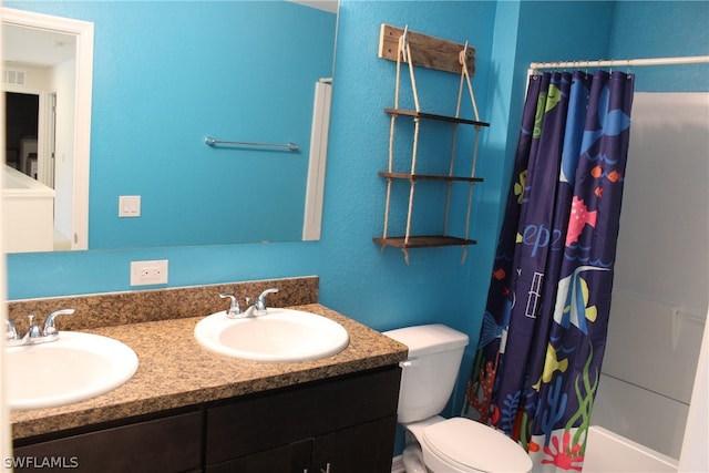 bathroom with dual vanity and toilet