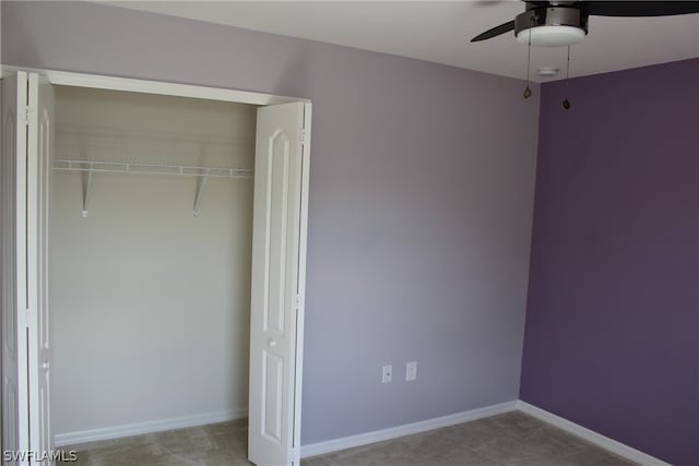 unfurnished bedroom with ceiling fan and a closet