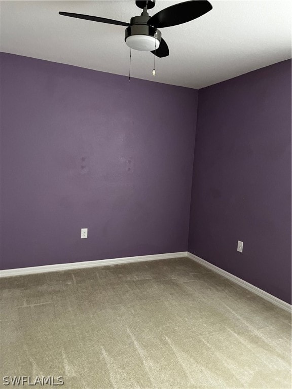 carpeted spare room featuring ceiling fan