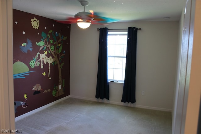 carpeted spare room featuring ceiling fan