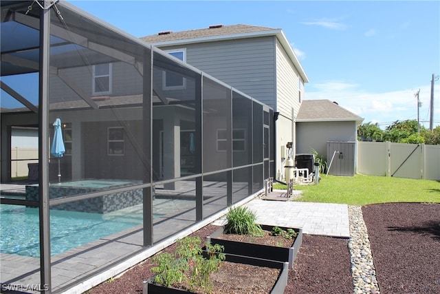 back of house with glass enclosure, a patio area, and a fenced in pool