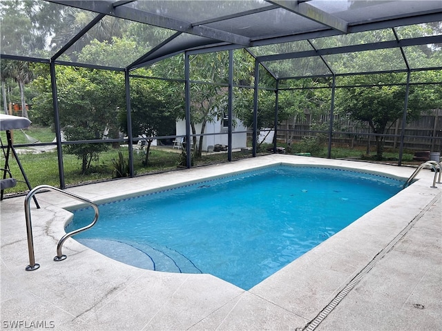 view of swimming pool featuring a patio and glass enclosure