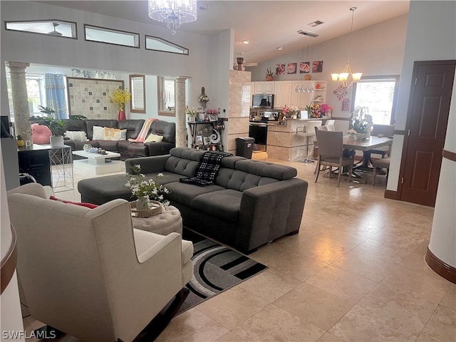 living room with light tile patterned flooring, a notable chandelier, and high vaulted ceiling