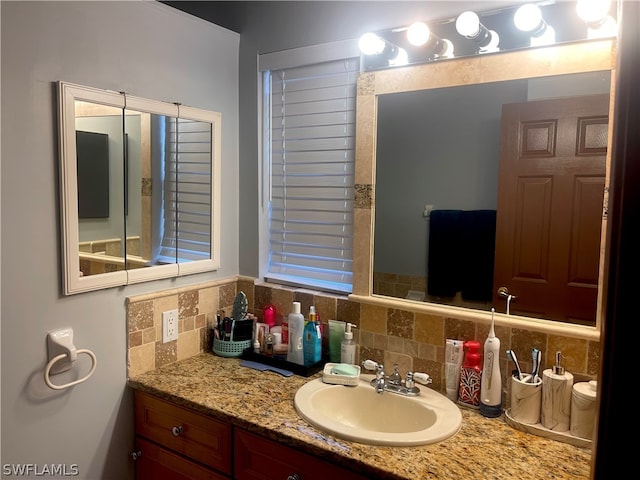 bathroom with vanity and tasteful backsplash