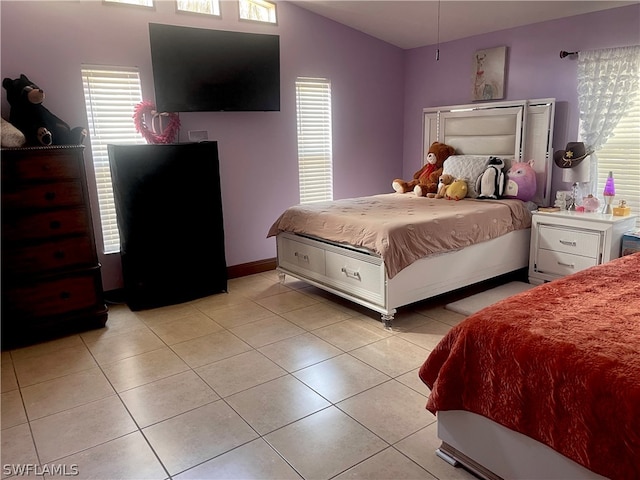 bedroom featuring light tile patterned flooring, multiple windows, and vaulted ceiling