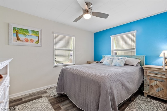 bedroom with multiple windows, dark hardwood / wood-style flooring, and ceiling fan