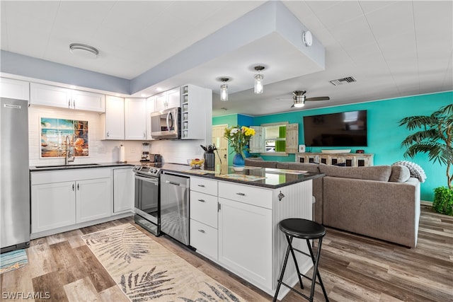 kitchen featuring sink, white cabinets, hardwood / wood-style flooring, and stainless steel appliances