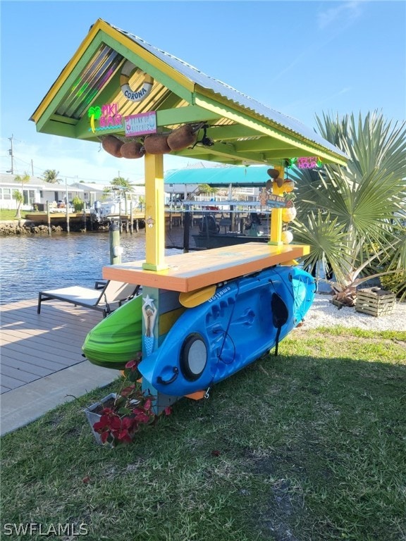 dock area featuring a water view and a lawn