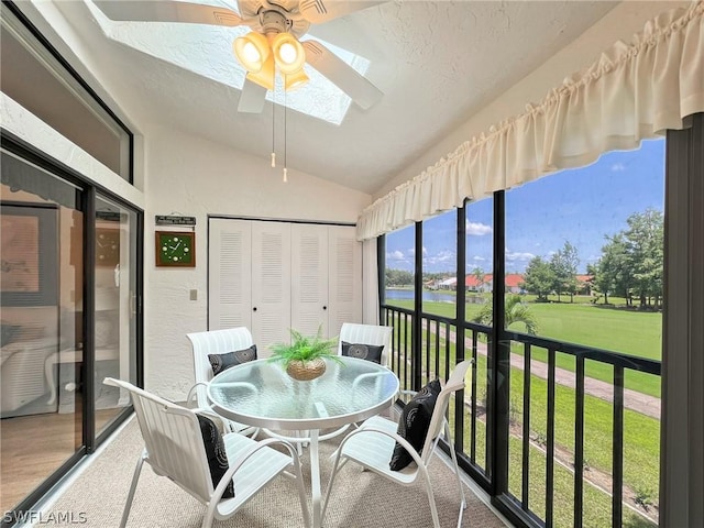 sunroom / solarium featuring ceiling fan and vaulted ceiling with skylight