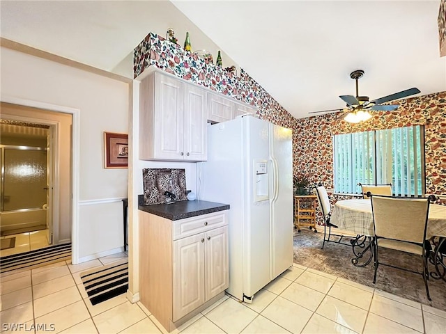 kitchen featuring light tile patterned flooring, white refrigerator with ice dispenser, white cabinets, and ceiling fan