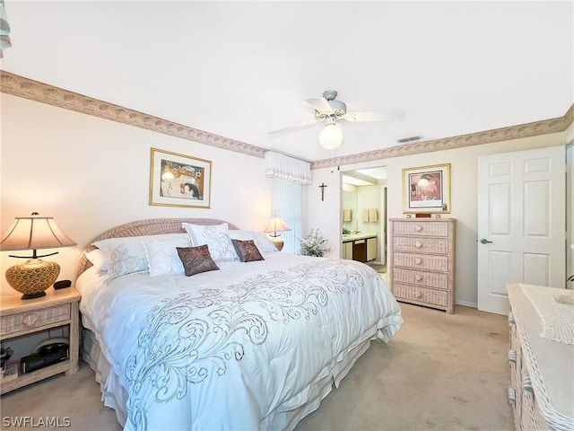 bedroom with connected bathroom, light colored carpet, and ceiling fan