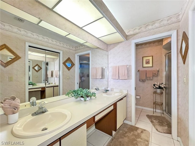 bathroom featuring tile patterned flooring, vanity, and a shower with door