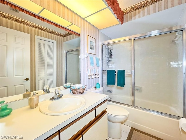 full bathroom with vanity, combined bath / shower with glass door, tile patterned floors, and toilet