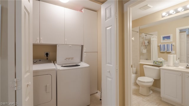 laundry area featuring light tile patterned flooring, sink, cabinets, and independent washer and dryer