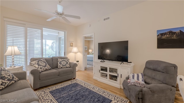 living room with light hardwood / wood-style flooring and ceiling fan