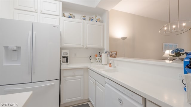 kitchen with sink, white cabinetry, white appliances, and decorative light fixtures