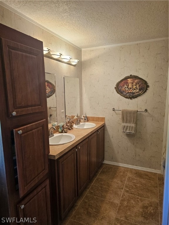 bathroom featuring dual vanity, tile patterned floors, and a textured ceiling