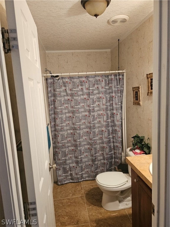 bathroom with vanity, toilet, a textured ceiling, and tile patterned flooring