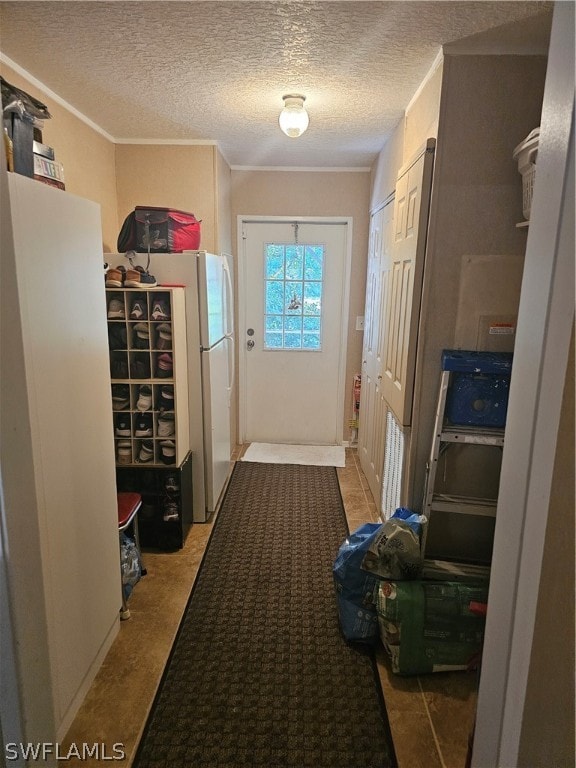 doorway to outside with crown molding and a textured ceiling