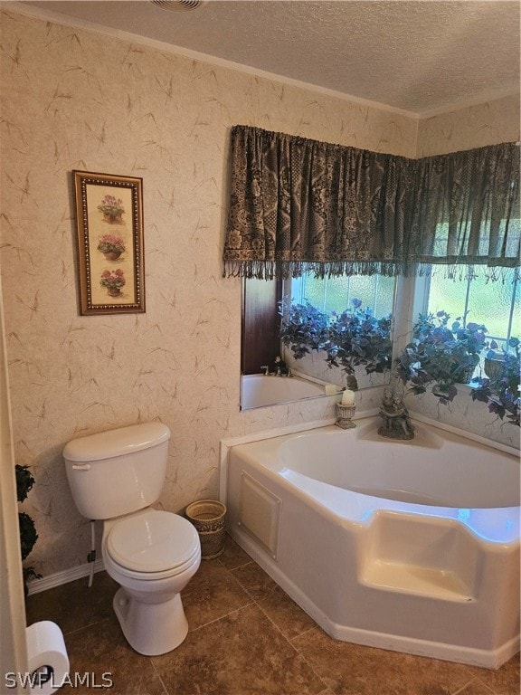 bathroom featuring tile patterned floors, a bath, toilet, and a textured ceiling