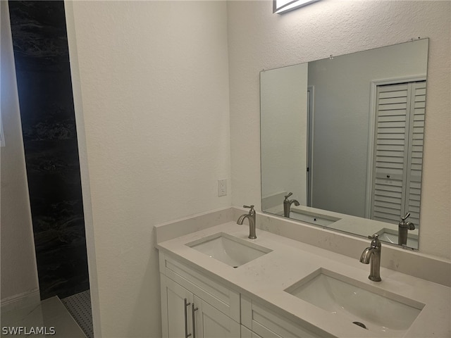 full bathroom featuring a closet, a sink, and double vanity