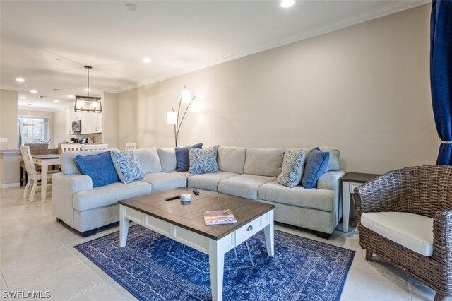 living room with a notable chandelier, crown molding, and light tile patterned floors