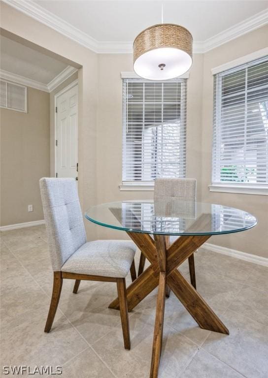 tiled dining room featuring ornamental molding