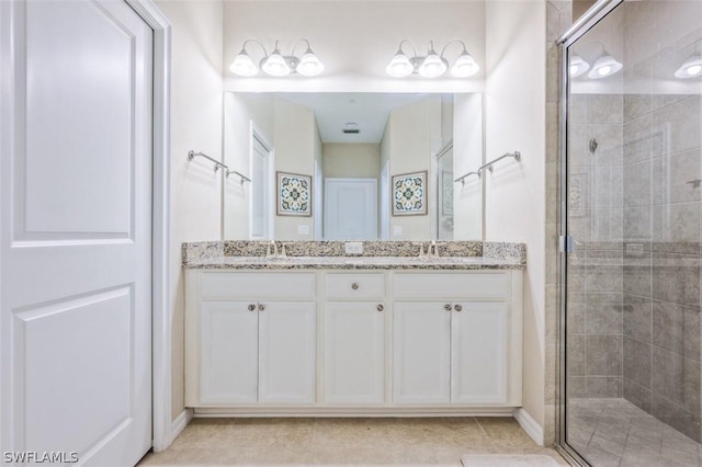 bathroom with tile patterned floors, walk in shower, and vanity