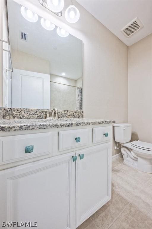 bathroom featuring toilet, vanity, a shower with curtain, and tile patterned flooring