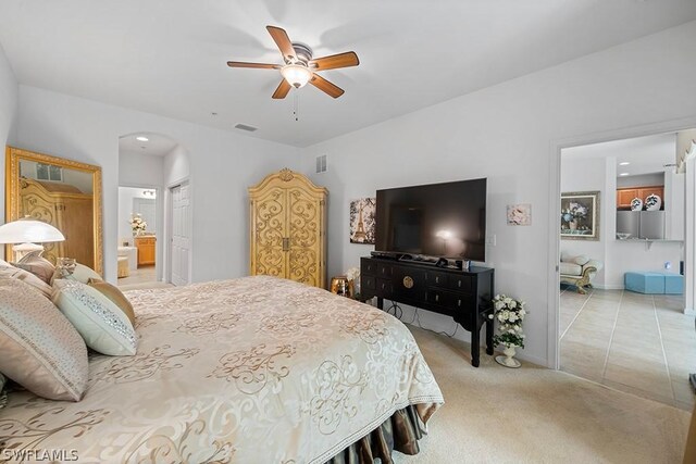 bedroom with light carpet, ensuite bath, a closet, and ceiling fan