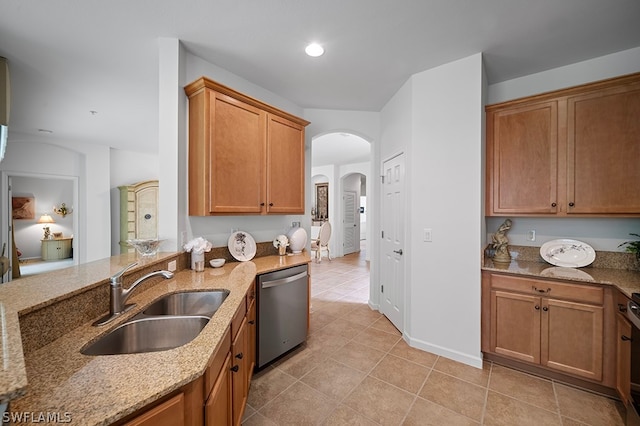 kitchen with sink, light tile patterned floors, dishwasher, range, and light stone counters