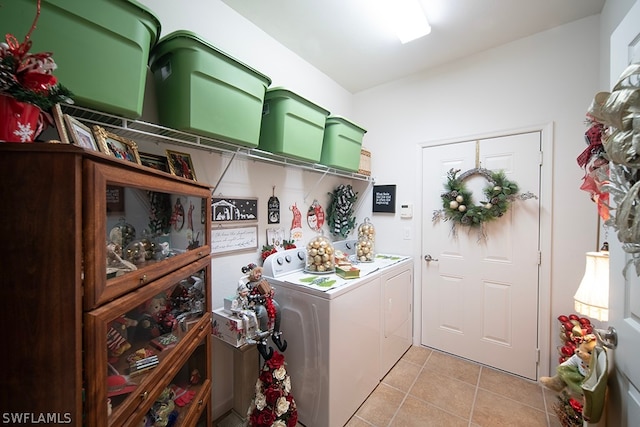 laundry area with washing machine and clothes dryer and light tile patterned floors