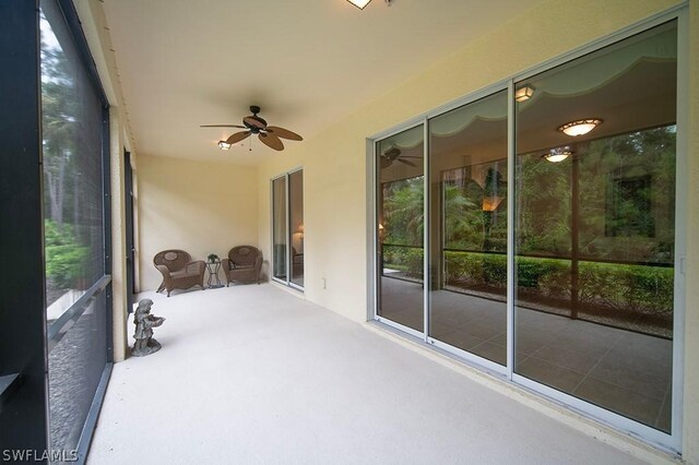 unfurnished sunroom featuring ceiling fan and plenty of natural light