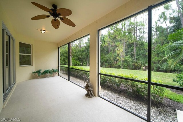 unfurnished sunroom with ceiling fan