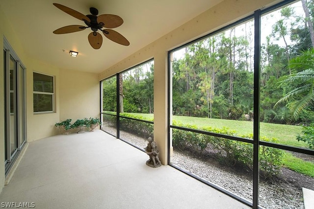 unfurnished sunroom with ceiling fan