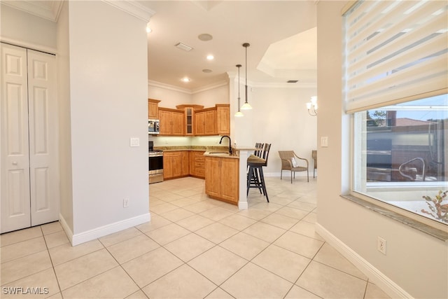 kitchen with a breakfast bar, sink, hanging light fixtures, light tile patterned floors, and stainless steel appliances