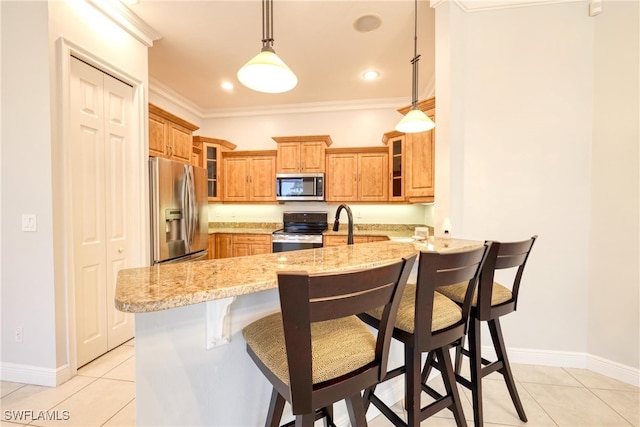 kitchen featuring a breakfast bar area, appliances with stainless steel finishes, hanging light fixtures, light stone countertops, and kitchen peninsula