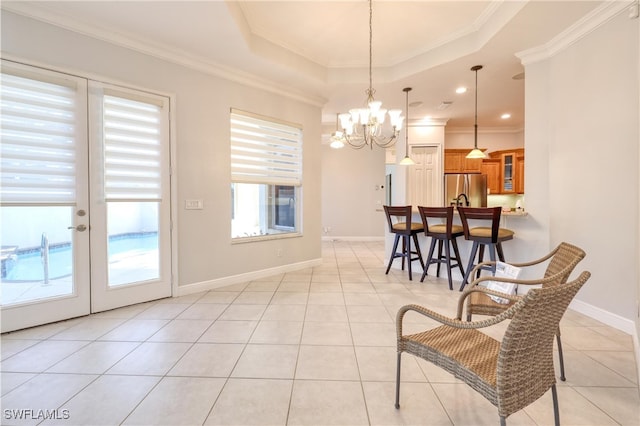 tiled dining area featuring a raised ceiling, crown molding, plenty of natural light, and french doors