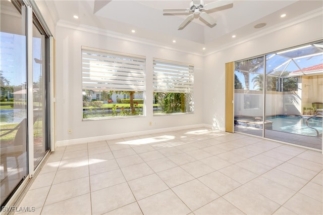 tiled spare room with crown molding, ceiling fan, and a tray ceiling