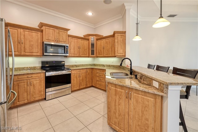 kitchen with sink, a breakfast bar area, kitchen peninsula, pendant lighting, and stainless steel appliances