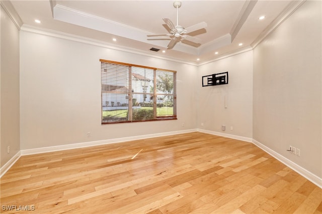 unfurnished room featuring crown molding, a tray ceiling, ceiling fan, and light wood-type flooring