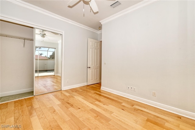 unfurnished bedroom featuring wood-type flooring, crown molding, ceiling fan, and a closet